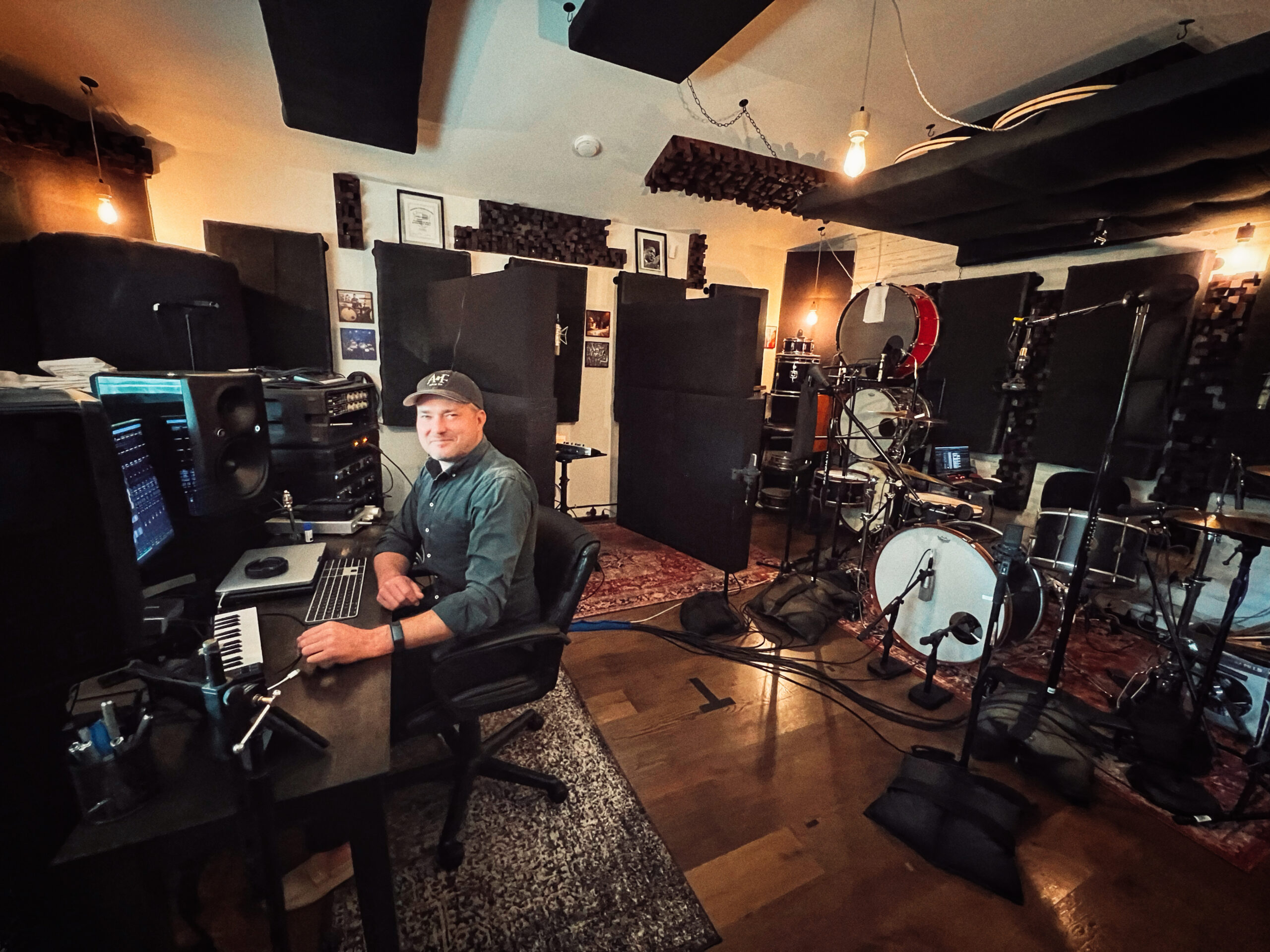 Recording engineer Blake Paulson seated in his control room at Vose Street Sound, surrounded by pro gear and drum kits.